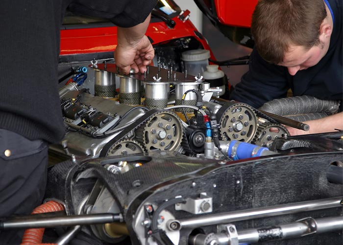 Technicians working on car engine
